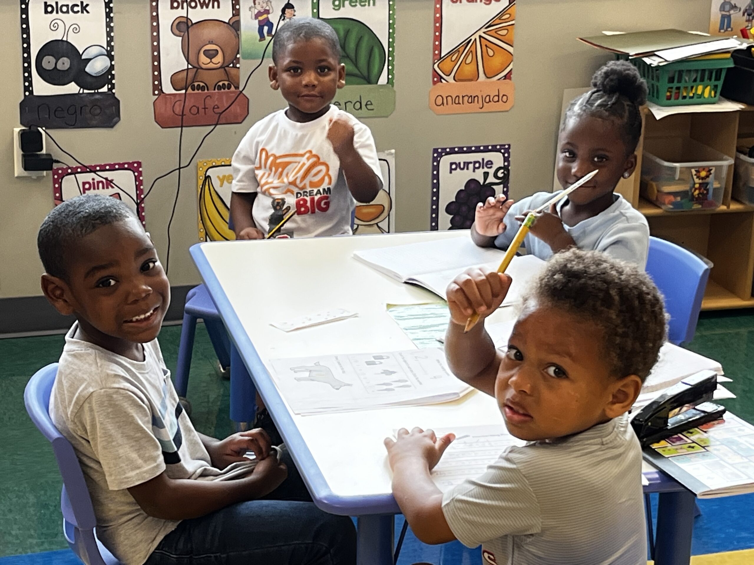 Toddlers sitting at the table practicing writing skills.